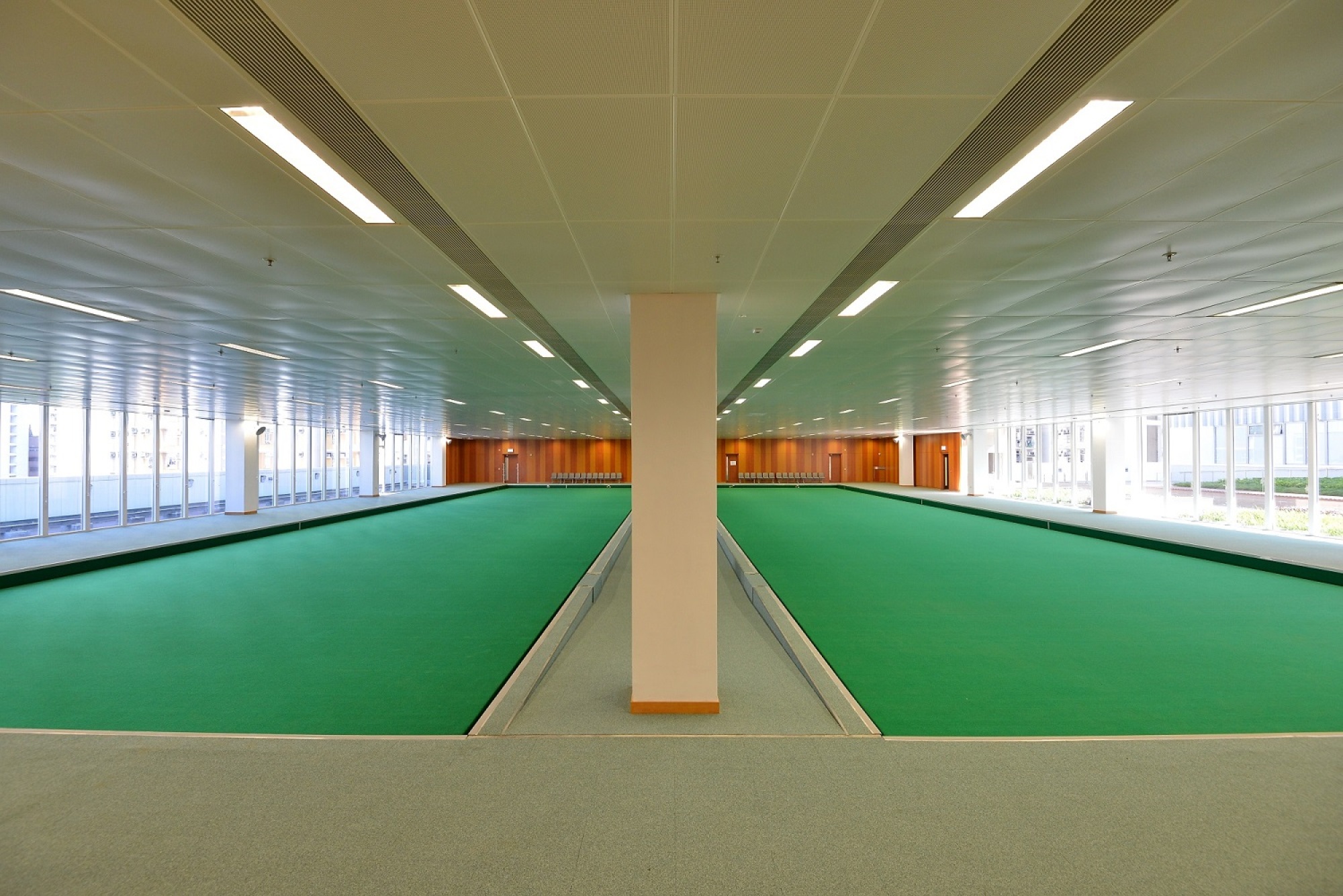 Spacious and bright indoor lawn bowls green at Yuen Chau Kok Sports Centre.