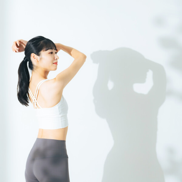 一名女子穿著運動服裝，展示了鍛鍊背肌的效果